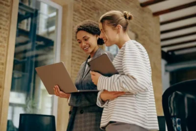 two young ladies with laptops